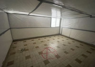 Désamiantage d'une pièce dans un bâtiment infecté